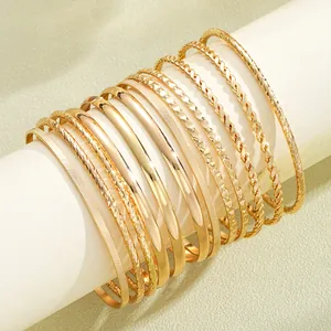 Dettaglio del set di 12 bracciali boho dorati con varie trame e motivi incisi