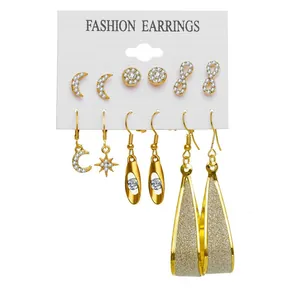 Dettaglio del set di 6 paia di orecchini dorati con strass bianchi e forme geometriche