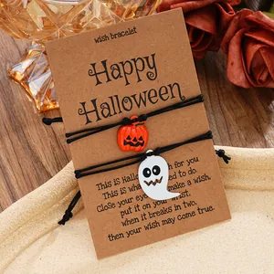 Detail von Halloween-Armbändern mit Kürbis- und Geist-Anhängern auf Kraftpapierkarte