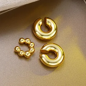 Three-piece set of polished gold C-shape ear cuffs with smooth and beaded textures