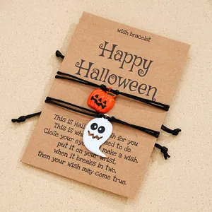 Details von Halloween-Armbändern mit Kürbis- und Geist-Anhängern auf einer Wunschkarte