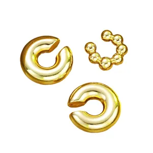 Three-piece gold C-shaped ear cuff set with smooth and beaded textures on white background