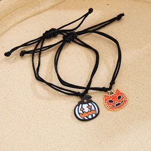Halloween-Armbandset mit Kürbis und Geisterkatze auf sandigem strukturiertem Grund