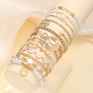 Bohemian gold layered bracelet set with daisy charms and white faux pearls
