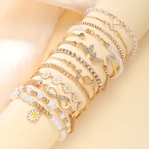 Multilayer gold bracelet set with daisies, pearls, and hearts on elegant fabric