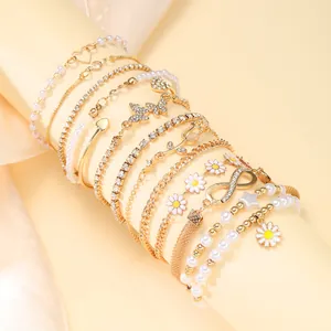 Chic 12-piece gold bracelet set with pearls, daisies, butterflies, and infinity charms