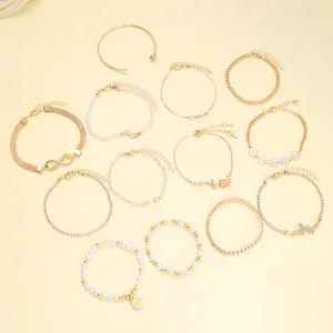 Detailed set of 13 gold-toned bracelets featuring daisy, heart, and pearl charms