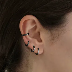 Detail von vierteiligem schwarzem Punk-Ohrring-Set inklusive Hoops und Cuffs am Ohr