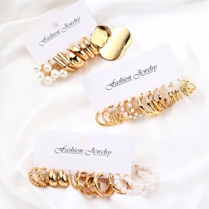 Set di 17 orecchini placcati in oro con perle e cerchi a spirale su seta bianca