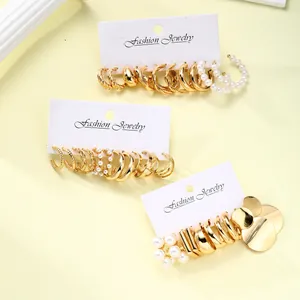 Set da 17 paia di orecchini dorati con perle e design a spirale su cartellini
