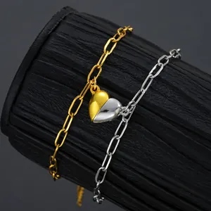 Juego de pulseras de corazón magnético en oro y plata en soporte negro