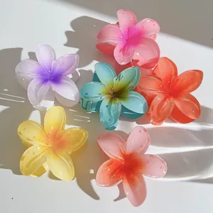 Macro view of 7cm plumeria flower hair claws in multiple gradient resin colors