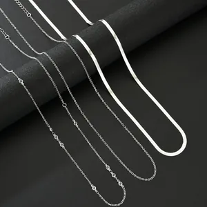 Detailed view of silver layered snake chain necklaces and zircon accents on black stand