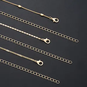 Three gold body chains with sequins and pearls shown on a black background