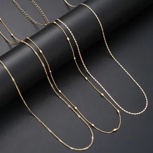 Close-up of layered gold chain belts with small beads and lobster clasp details
