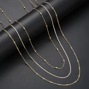 Close-up of a layered golden waist chain set with beads and flat square link textures