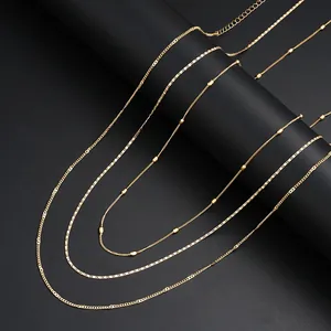 Detail of layered gold waist chain featuring sequins and pearls on black background