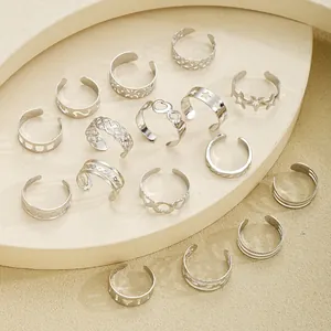 Detailed close-up of 15-piece adjustable silver rings with heart and star patterns