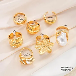 Set di 7 anelli dorati da donna con perle irregolari e finiture in metallo martellato