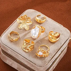 Set di 6 anelli dorati con perla barocca, design floreale e finiture testurizzate