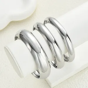 Dettaglio di tre bracciali a cupola in argento lucido su un supporto professionale