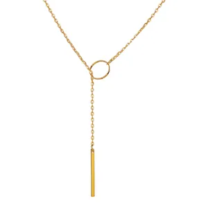 Detail of a gold lariat necklace featuring a circular ring and vertical bar pendant