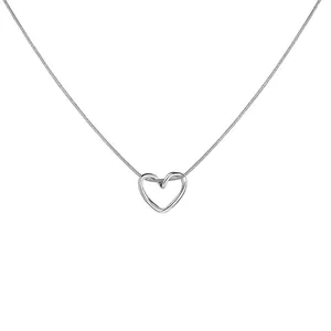 Macro detail of silver hollow heart pendant on a fine snake chain necklace with sleek finish