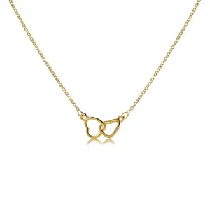Close-up of golden double-heart necklace with delicate hollow pendant and cross chain link