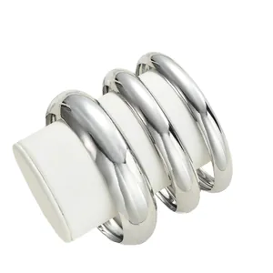 Set di tre bracciali rigidi rotondi in metallo argento lucido su supporti bianchi