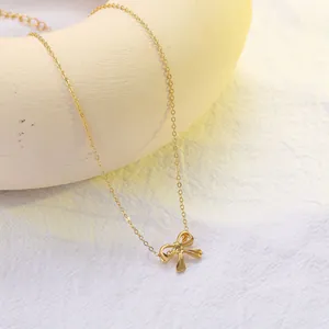 Elegant gold bow necklace with hollow design and adjustable chain on a clean background