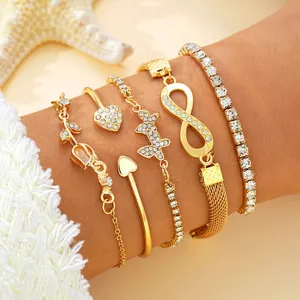 Primer plano detallado de un conjunto de cinco pulseras doradas con dijes de corazones