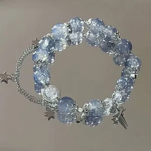 Elastic beaded bracelet with icy crackle blue beads and silver star pendants