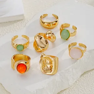 Detalle del set de 7 anillos dorados con piedras acrílicas y textura irregular