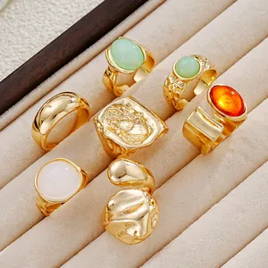 Detalle de anillos dorados vintage con piedras de acrílico en una bandeja de terciopelo