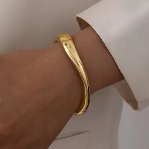 Polished gold irregular liquid metal wide cuff bracelet with asymmetric design