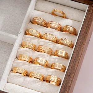 Macro view of 16-piece gold toe ring set with star and heart designs in a wooden box