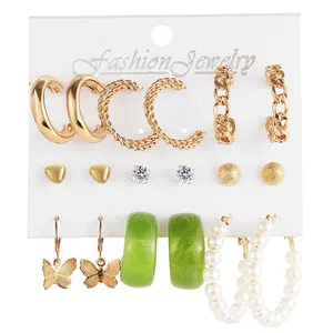 Detailed view of 9-piece earring set with gold alloy, green resin, and faux pearls