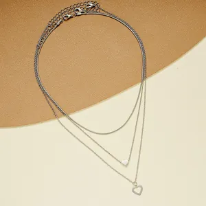 Détail d'un collier triple rang en argent avec pendentifs cœur et fermoir homard
