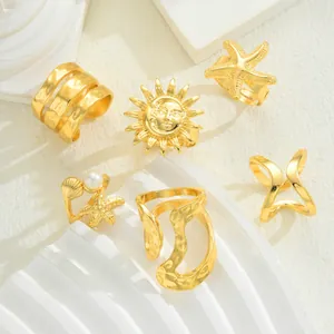 Detail eines 6-teiligen Goldring-Sets mit Sonnen-, Seestern- und Perlenverzierung