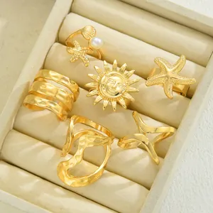 Detailaufnahme eines sechsteiligen goldenen Ringsets mit Seestern-, Muschel- und Sonnendesigns