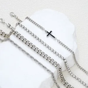 Dettaglio del set di 4 braccialetti d'argento con ciondolo a croce e catena tennis di cristalli
