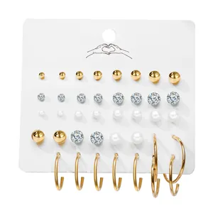 Set de 20 pares de pendientes de aro dorados con perlas y circonitas en una tarjeta