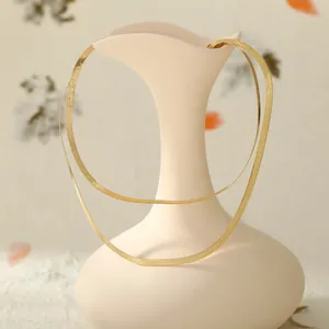 Detailansicht der mehrlagigen goldenen Schlangenkette an einer Keramikvase Deko