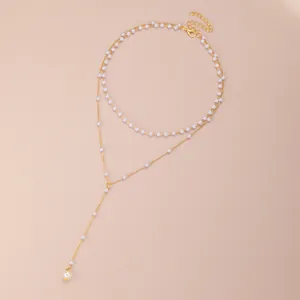 Detail of gold-tone multi-layer Y-shaped necklace with white pearls and adjustable lobster clasp