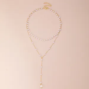Detail of gold-tone double-layer Y-shaped necklace with white pearls and adjustable clasp
