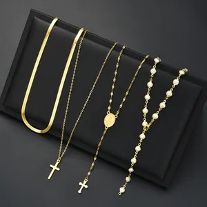 Détail d'un ensemble de quatre colliers dorés avec perle, croix et médaille religieuse