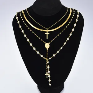 Ensemble de colliers dorés multicouches avec pendentifs croix et perles sur buste noir