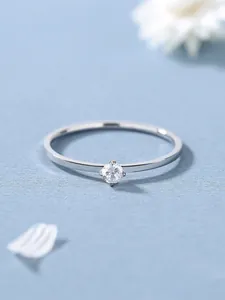 Gros plan détaillé d'une bague minimaliste en argent sertie d'un diamant solitaire