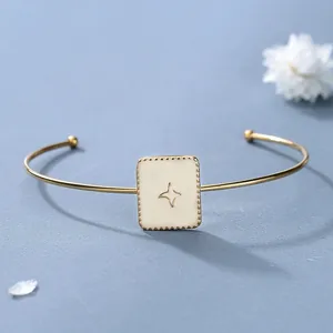 Bracciale rigido dorato con placca quadrata in smalto crema e stella incisa