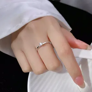 Bague minimaliste en argent avec un seul diamant montrée sur une main tenant une tasse